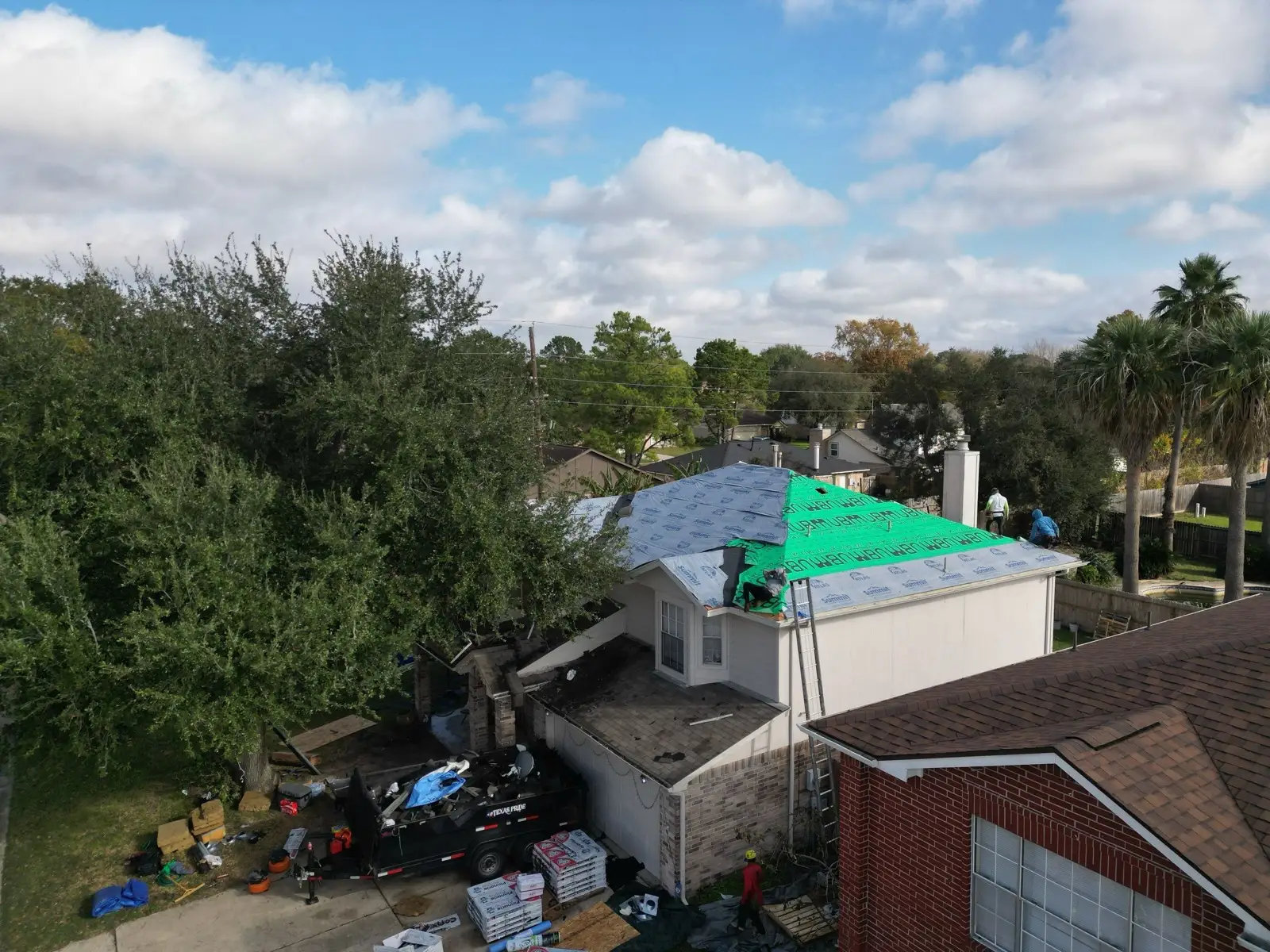 December 18. Green underlayment going on, the driveway staged with materials below.