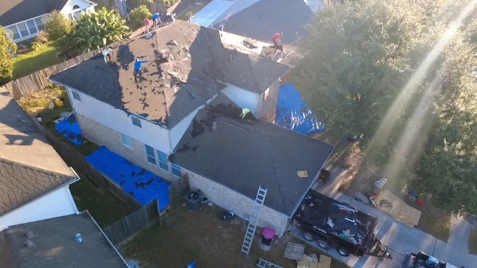 November 4. The drone up with the sun — tear-off underway, tarps skirting the house.