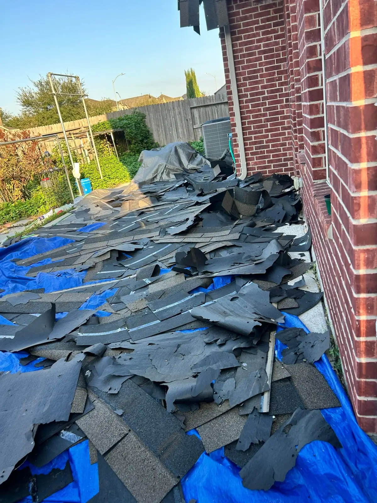 November 18. Torn shingles landing on tarps laid along the house.