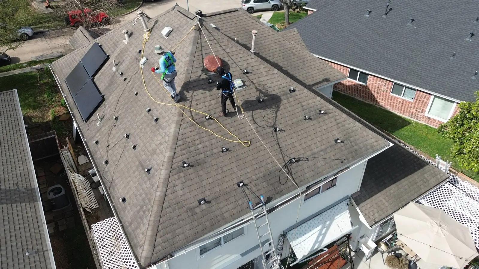 March 2. Panels down, mounts still dotting the old shingles — ropes on, working the slope.