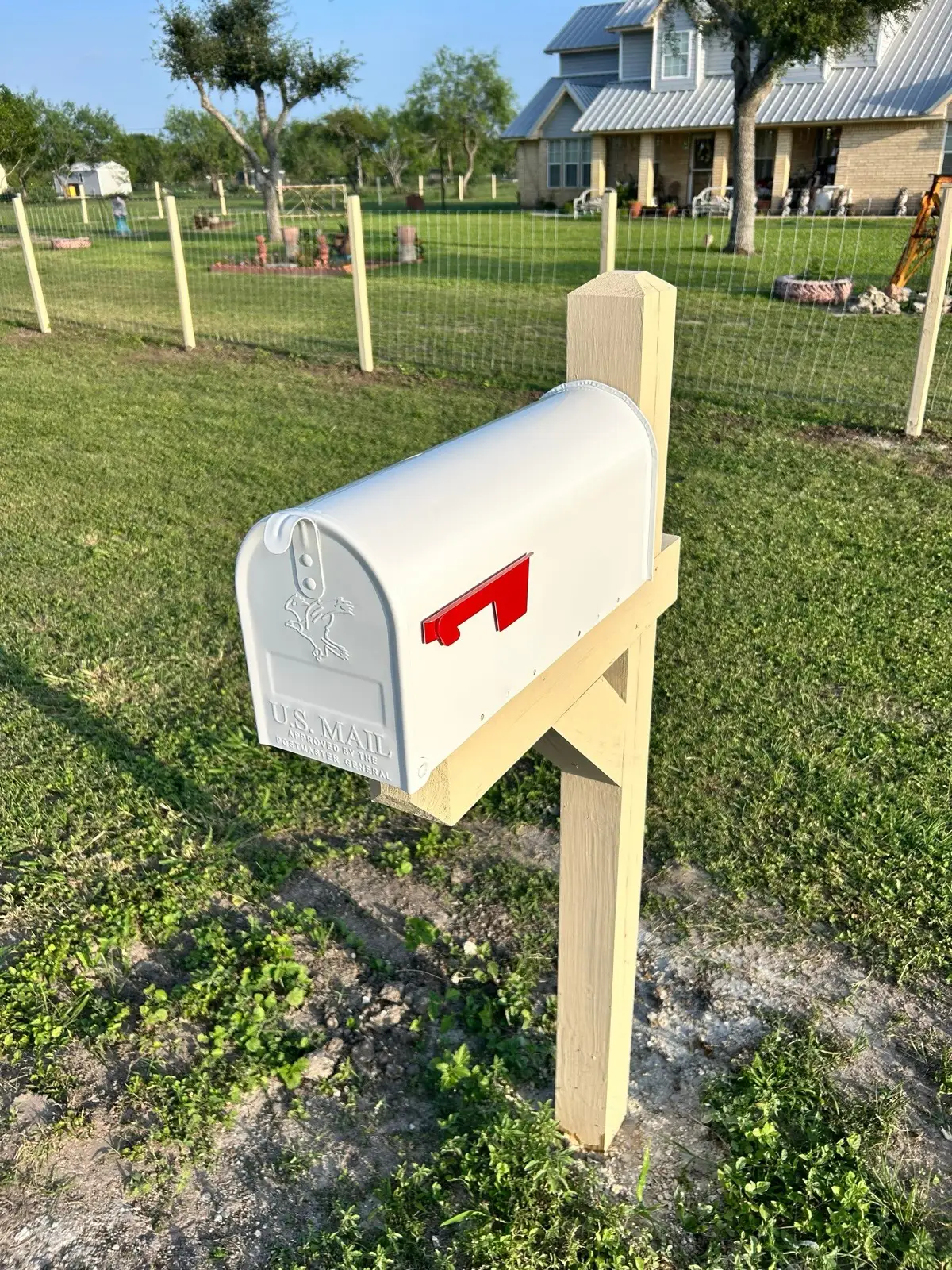 May 5, evening. A new mailbox on a new post, the rebuilt fence line running behind it.