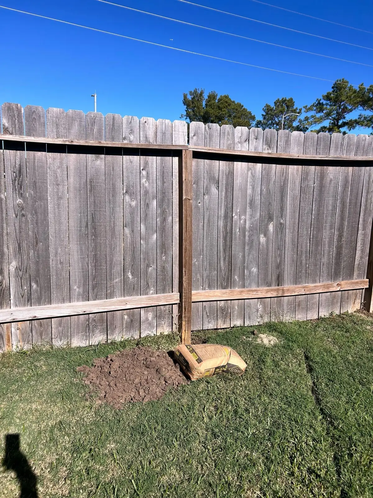 November 10. A new post set against the old line, concrete mix at its base.