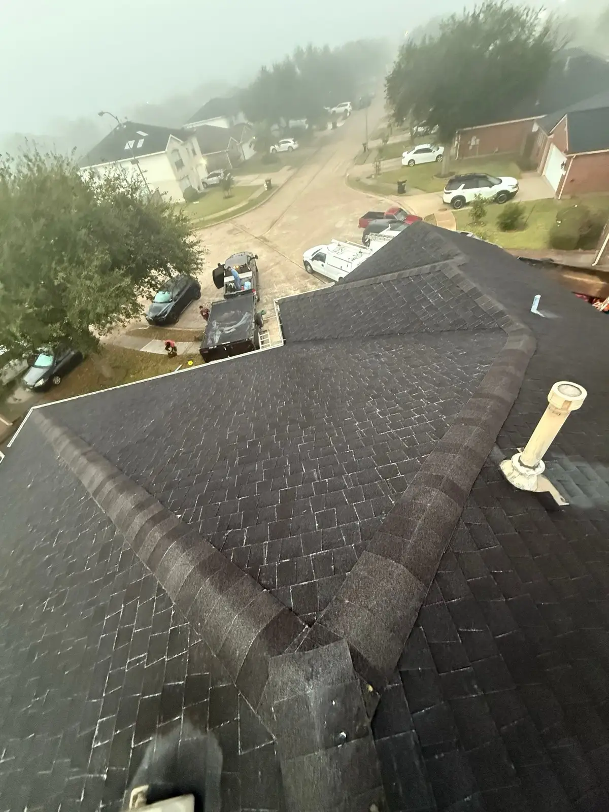 December 12. Worn shingles and ridge caps, the crew's trailers just visible through the fog below.