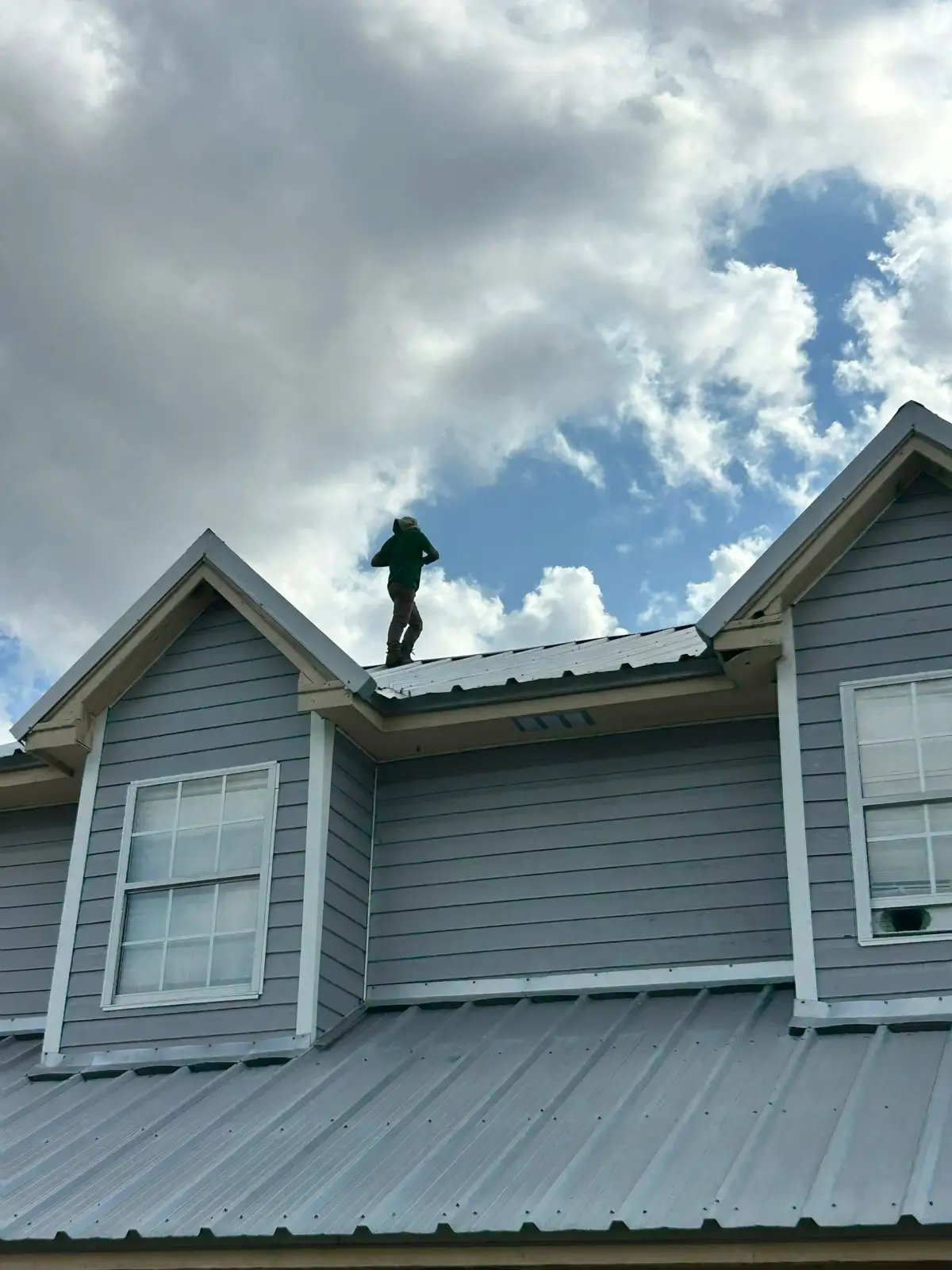 November 20. An inspector at the ridge of the original metal roof.