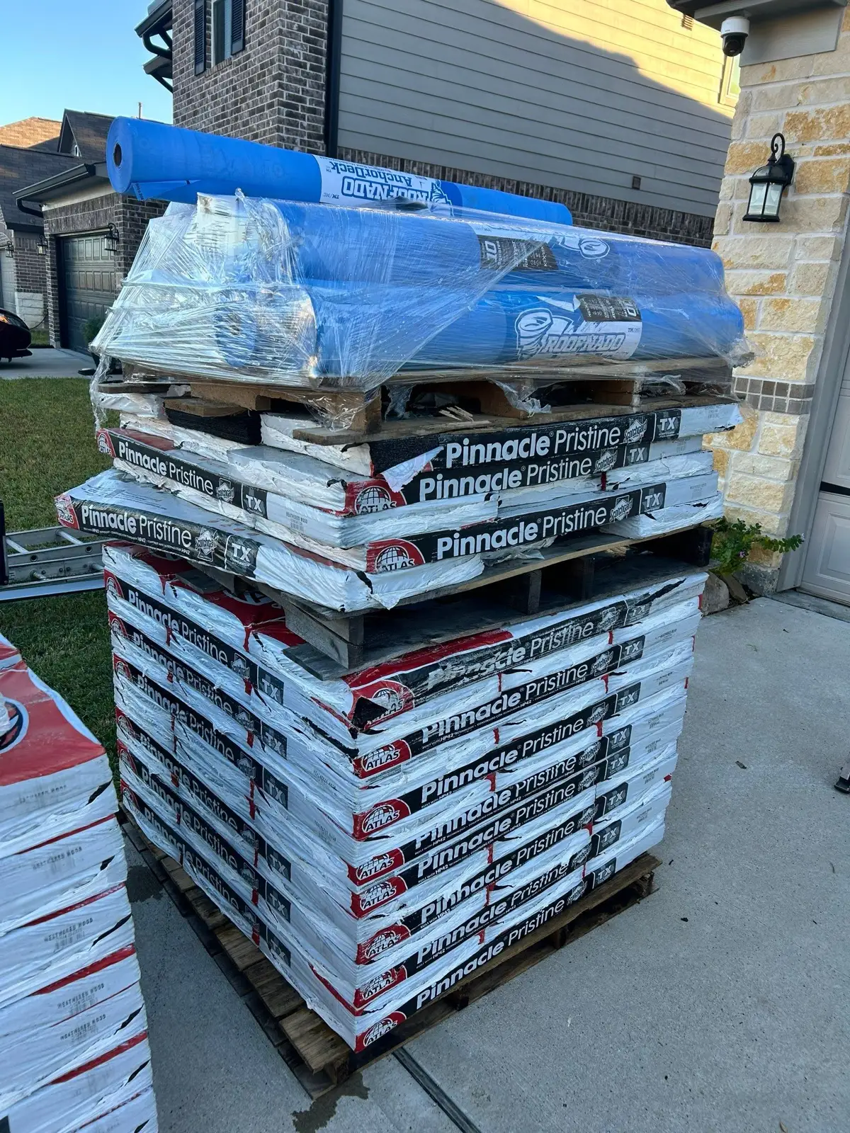 October 29. Atlas Pinnacle Pristine bundles and RoofNado AnchorDeck underlayment rolls on the driveway pallet.