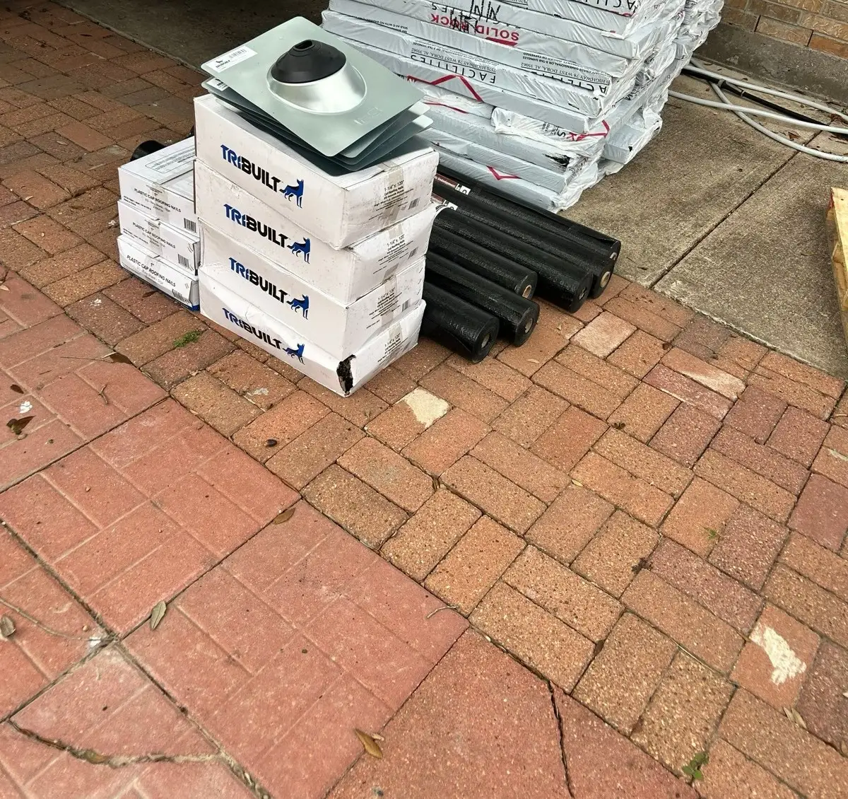 January 13. The spec staged on the driveway — shingle bundles, cap nails, felt rolls, new pipe flashings.