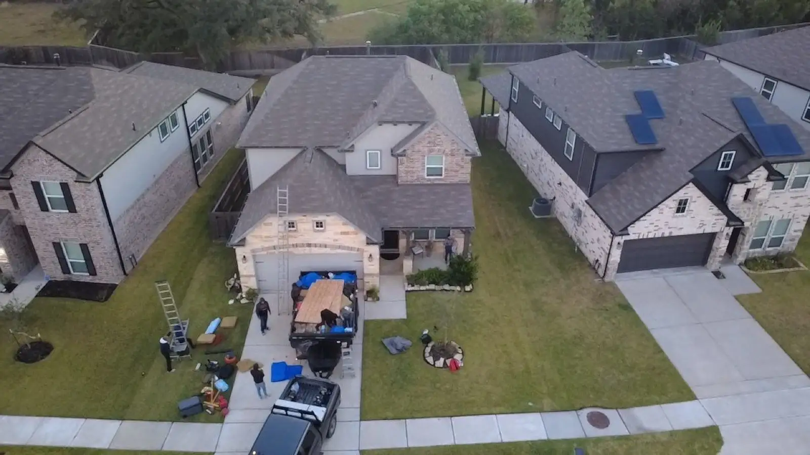 October 29. The crew stages in the driveway; the old roof gets its last aerial.