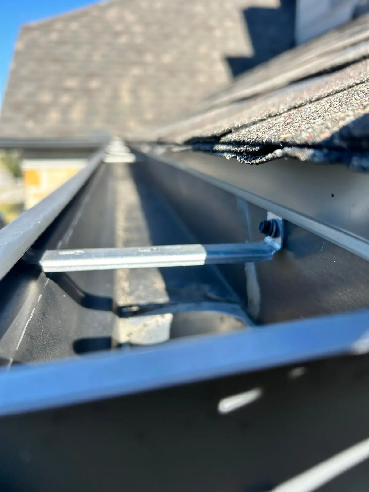November 10. Gutter interior — hanger, outlet, and sealant, checked up close.