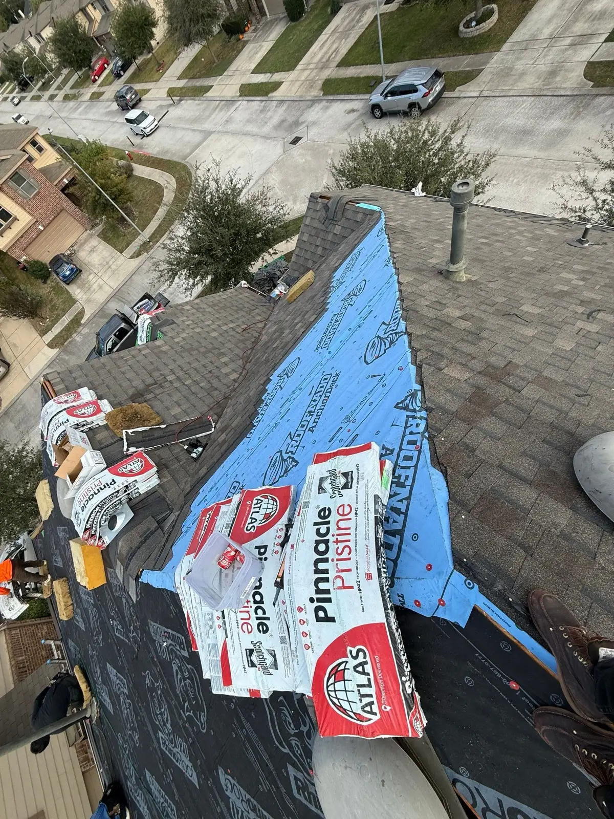 November 18. Shingles going on over the underlayment, bundle wrappers still on the roof.
