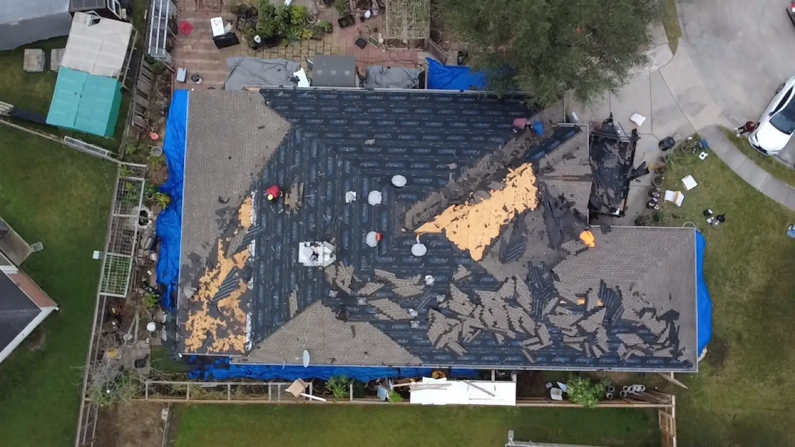 January 13. Straight down mid-tear-off — old shingle, bare deck, and underlayment in one frame.