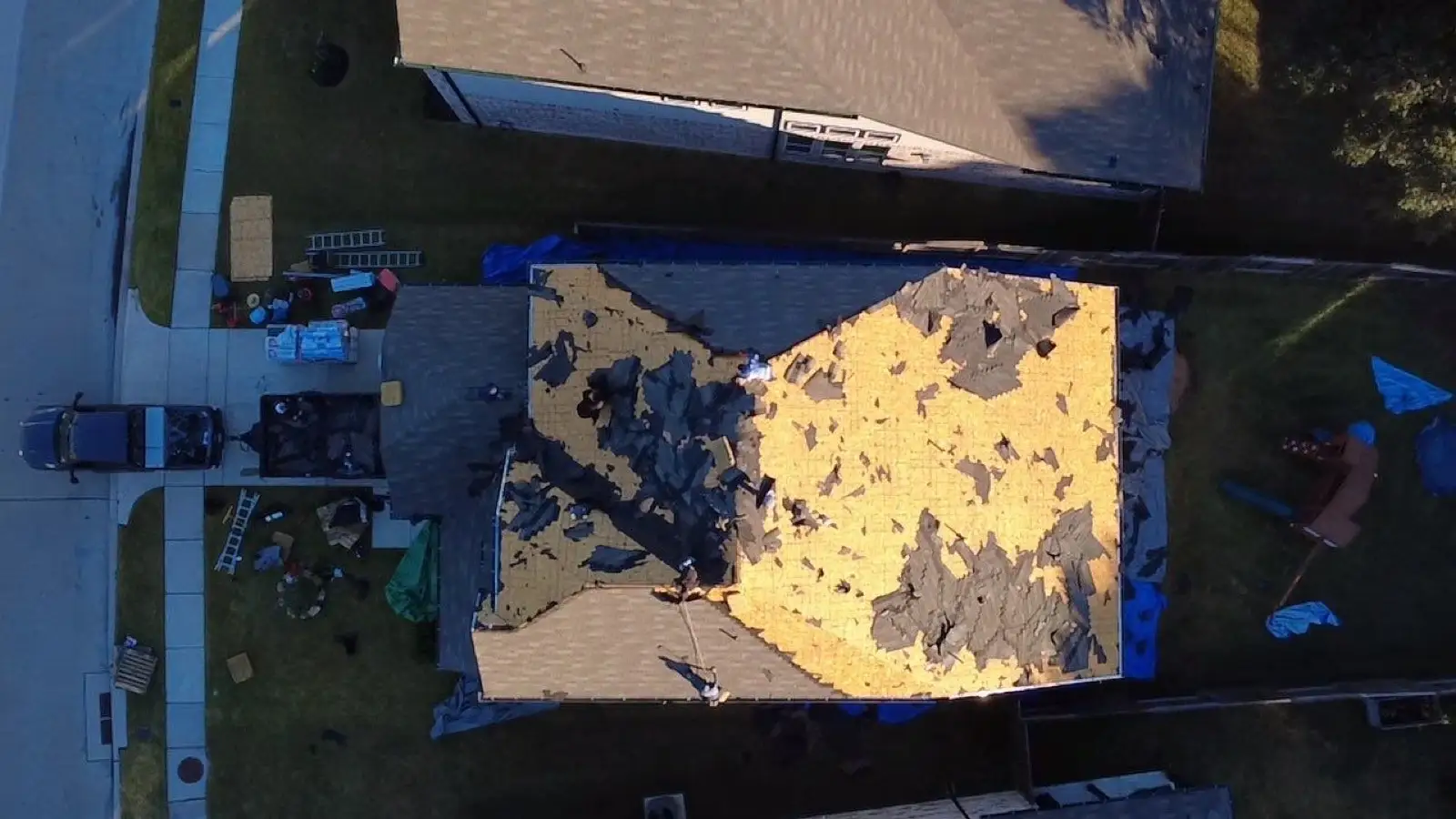 October 29. Mid tear-off from overhead — old shingles coming off in sections.