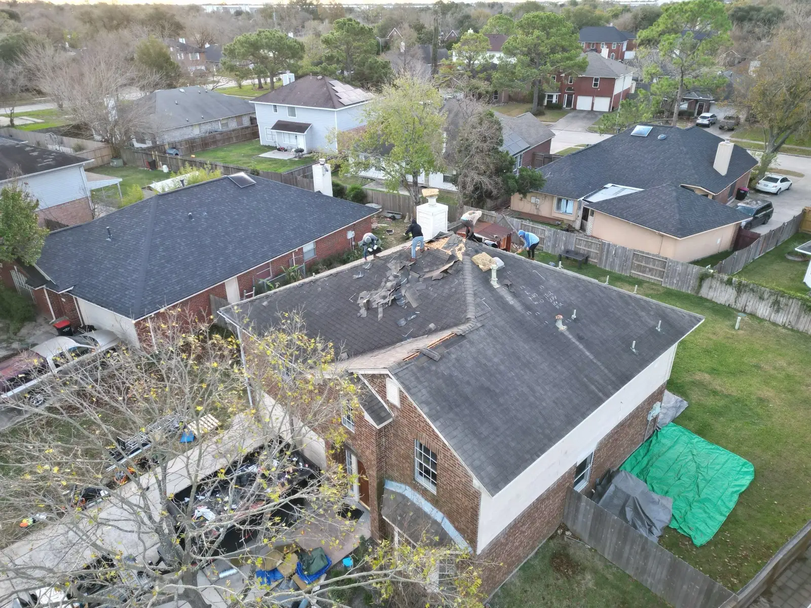 December 30. Tear-off begins at the chimney — inspection chalk still visible on the far slope.