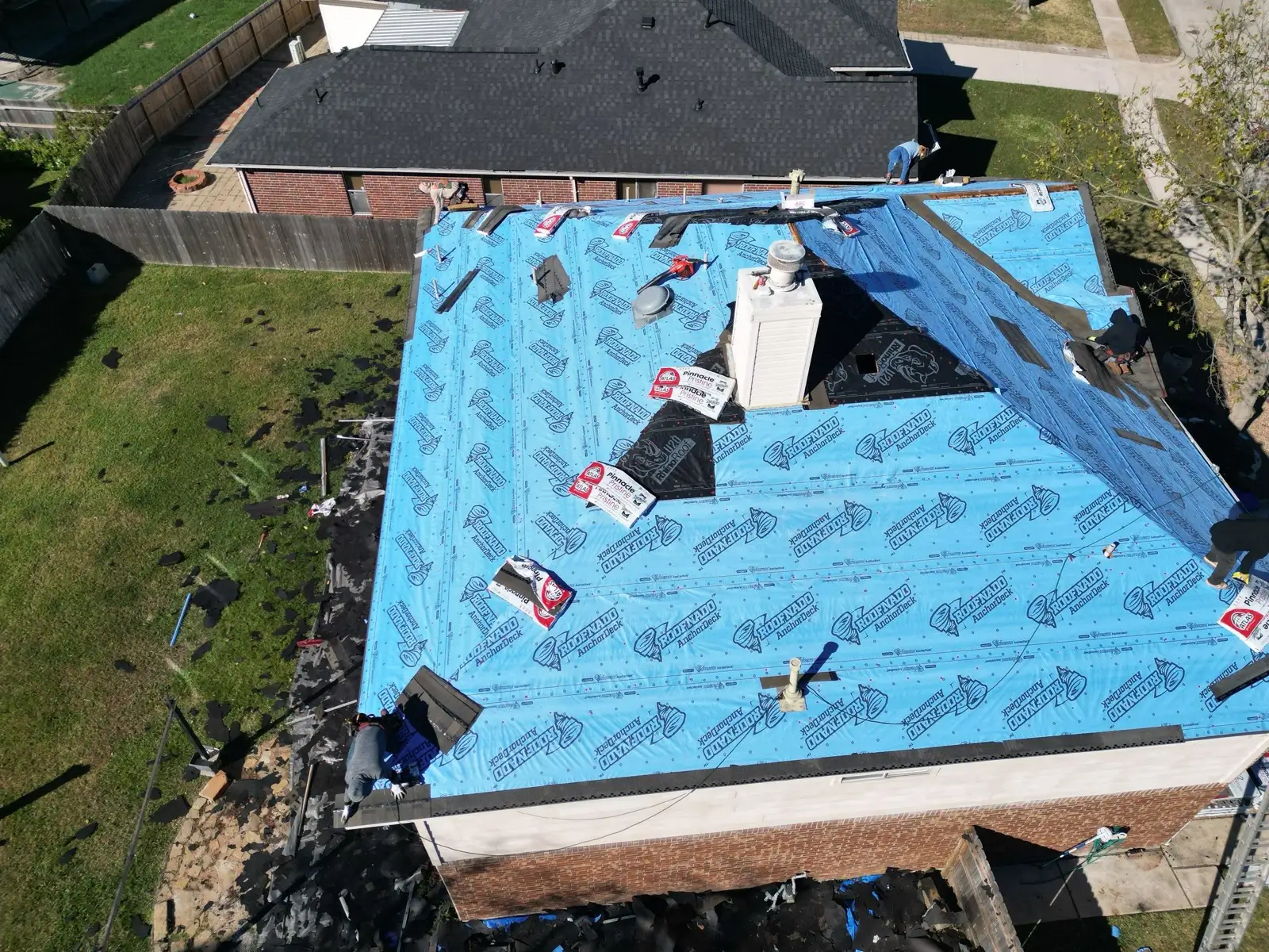 December 30. The deck sealed in synthetic underlayment, labeled shingle bundles staged on the slopes.
